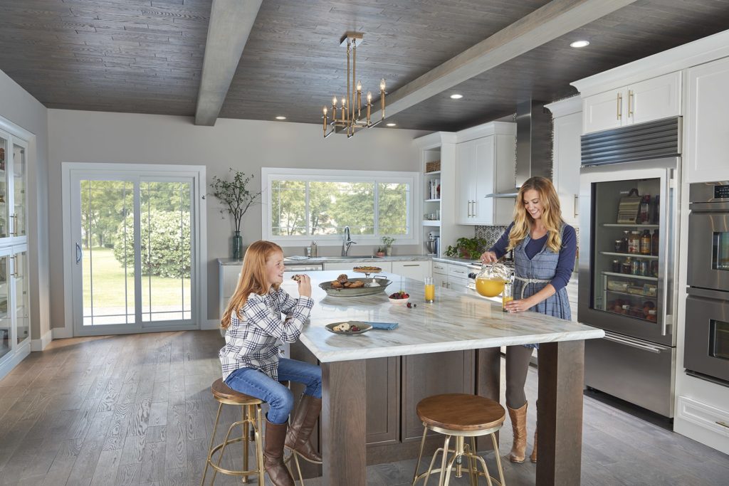 Mother and daughter laughing around kitchen island